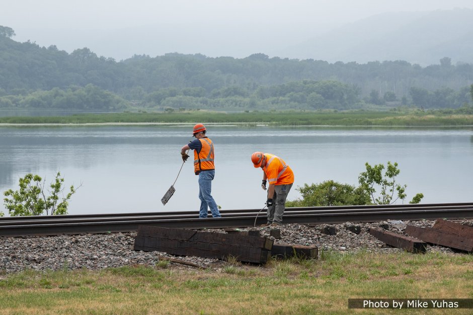 A couple workers manually remove the tie plates. These will be reused when the new ties are inserted.