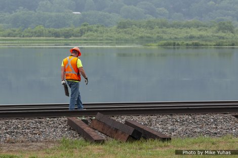 A couple workers manually remove the tie plates. These will be reused when the new ties are inserted.