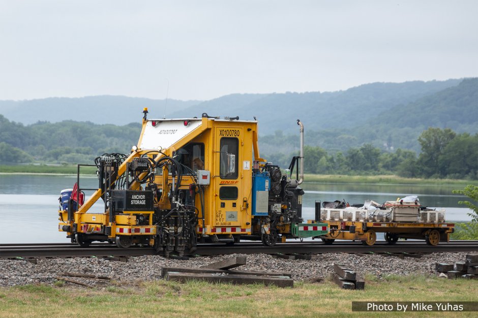 The Racine DAA (Dual Anchor Adjuster) pushes the rail anchors tight up against the new ties. This machine rides on a chassis similar to the DASP seen earlier. The toolheads are oriented to squeeze the anchors, not spread them.