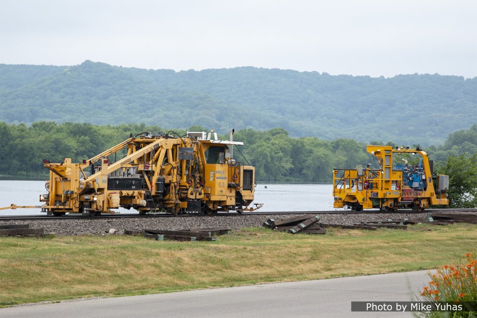 Self-raising and lining tamper. The main unit (at left) lifts and lines track, clamping and tamping alternate ties. The drone unit (at right) tamps the ties untamped by the main unit. A shadowboard is seen in about the center of the main machine at left.